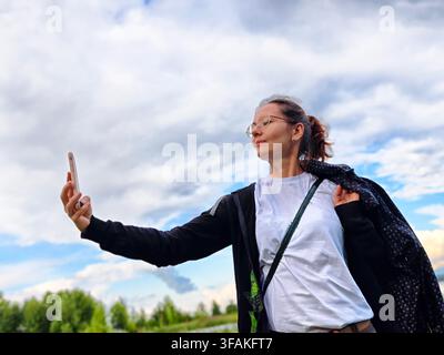 Donna di mezza età scatta un selfie durante una bella avventura di viaggio nella natura Foto Stock