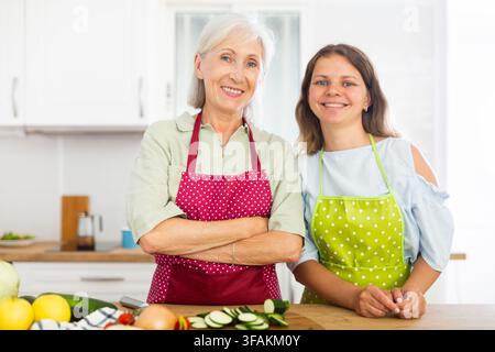 Ritratto di sorridenti donne anziane e giovani in grembiuli Foto Stock
