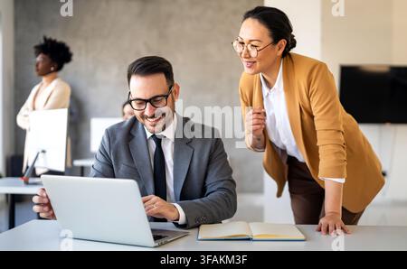 Gruppo di giovani imprenditori che lavorano in team e comunicano nell'ufficio aziendale Foto Stock