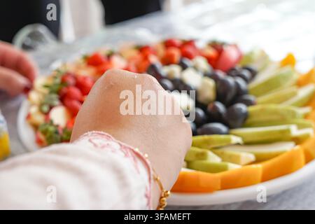 Una vivace assortimento di frutti tropicali tagliati tra cui fragole, uva, mele, pere, papaya e mango disposti ordinatamente su un vassoio da portata. Foto Stock