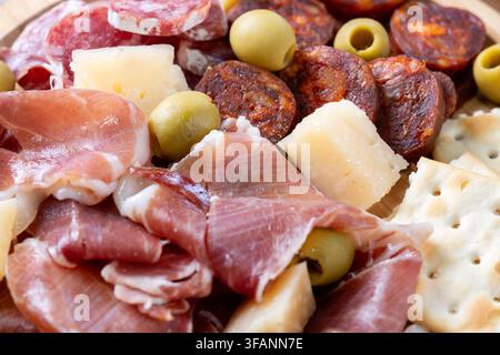 Tagliere di charcuterie spagnola con carni affumicate, formaggio e olive su piatto di legno Foto Stock