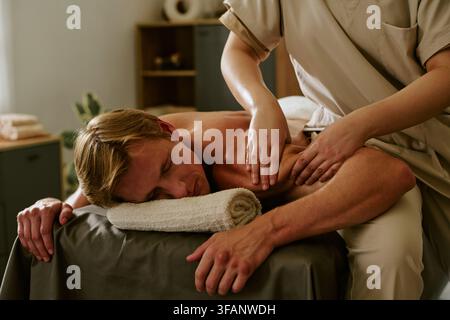 Uomo che riceve un massaggio professionale alle spalle in un centro benessere Foto Stock