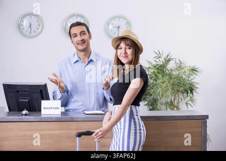 La giovane donna alla reception dell'hotel Foto Stock