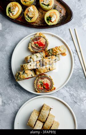 Rotoli di sushi fusion gourmet giapponesi su piatti Foto Stock