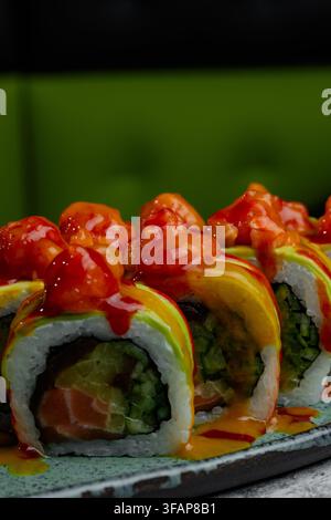 Prima piano di involtini di sushi con avocado e salsa piccante Foto Stock