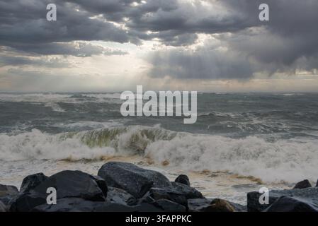 Le onde di un mare in tempesta si infrangono contro le rocce costiere di Città del Capo Foto Stock