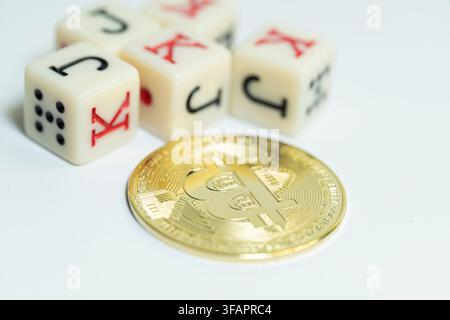 Bitcoin fisico lucido circondato da dadi da poker del casinò che mostrano il gioco d'azzardo del trading di criptovalute Foto Stock