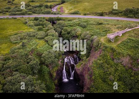 Ripresa aerea con drone delle Lealt Falls sull'Isle of Skye, Scozia, che mostra la cascata, la profonda gola, la piattaforma panoramica e il paesaggio verdeggiante. Foto Stock