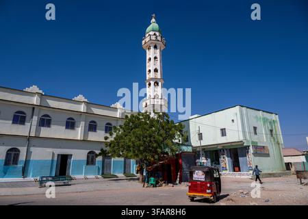 Moschea con minareto e edifici circostanti in una zona affollata di Garowe durante una giornata serena Foto Stock