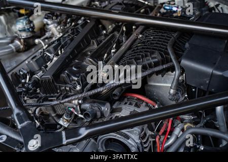 Componenti del motore di un'auto sportiva moderna, incluso il collettore di aspirazione e la barra di rinforzo del telaio Foto Stock