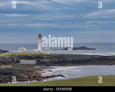 Fair Isle, UK - 22 maggio 2026: Il faro sud si erge sopra la costa rocciosa di Fair Isle UK sotto nuvole blu stratificate e un mare luminoso Foto Stock