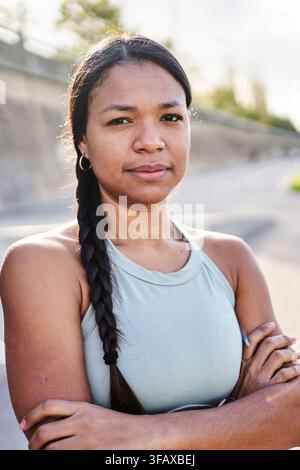 Donna millenaria africana in piedi in un parco che indossa abbigliamento sportivo Foto Stock