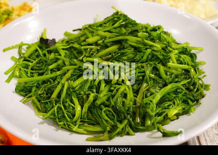 Spinaci d’acqua saltati verdure a foglia verde contorno stile casalingo Foto Stock