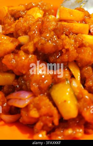 Pollo fritto dolce e aspro con ananas e cipolla, saltato colorato Foto Stock