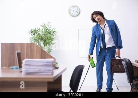Il giovane dipendente ubriaco in ufficio Foto Stock