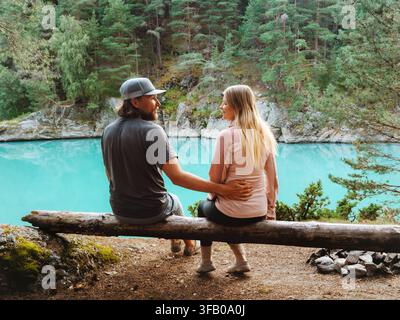 Coppia innamorata seduta su un tronco che conversa, viaggia insieme, campeggio, vacanze romantiche, fine settimana, relazione familiare, stile di vita uomo e donna amici Foto Stock