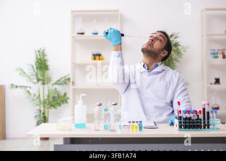 Giovane medico maschio che lavora in laboratorio Foto Stock