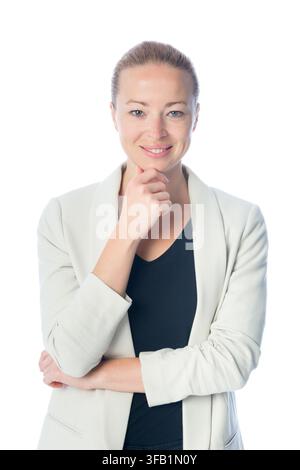 Ritratto in studio di una donna d'affari bionda pensierosa in un blazer grigio chiaro, che sorride dolcemente con la mano sotto il mento su uno sfondo bianco semplice Foto Stock