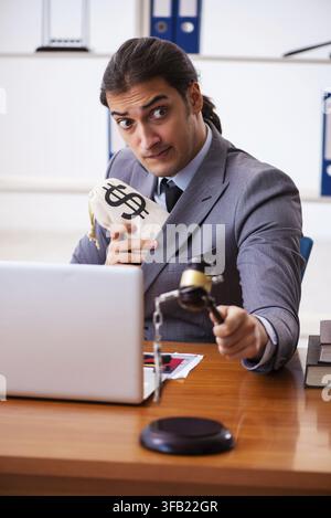 Giovane avvocato seduto in ufficio Foto Stock