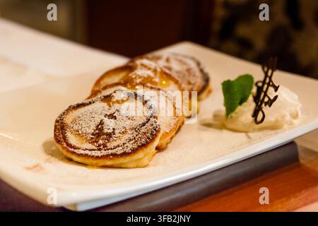 Frittelle con gelato spolverate di zucchero a velo Foto Stock