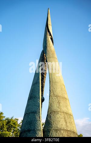 Budapest, Ungheria - 22 luglio 2026: Vista ad angolo basso del monumento centenario in bronzo strutturato che si erge contro un cielo blu chiaro durante l'ora dorata, con Foto Stock