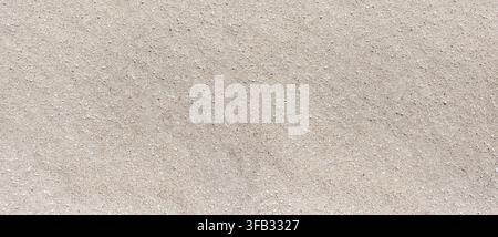 Texture di sabbia che mostra una superficie beige, neutra e granulosa con piccole pietre Foto Stock