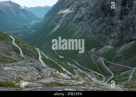 Passo di montagna tortuoso di Trollstigen con tornanti che attraversano una valle verde e ripida in Norvegia. Foto Stock