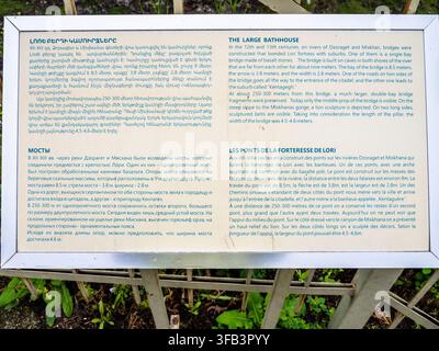 Lori Berd, Armenia - 18 luglio 2026: cartello esterno con descrizione della storia e informazioni sul bagno pubblico e sul ponte nella fortezza medievale di Lori Berd Foto Stock