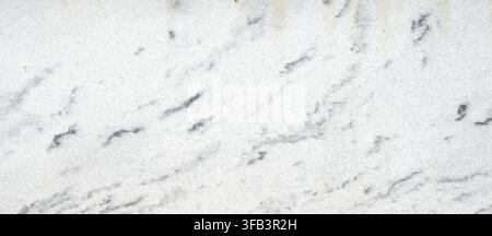 Vista ravvicinata orizzontale di una lastra di granito bianco non levigata con venature grigie, cristalli visibili, grana naturale e struttura minerale ruvida Foto Stock