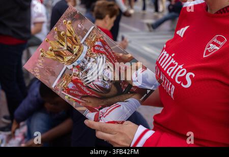 Un tifoso dell'Arsenal tiene il programma della partita dell'Arsenal FC per l'apertura casalinga della Premier League 2026/27 contro il Coventry City all'Emirates Stadium. Foto Stock