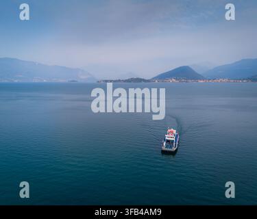 Vista panoramica aerea con drone del Lago Maggiore nell'Italia settentrionale, che mostra il vasto lago alpino, le montagne circostanti e il pittoresco lungolago Foto Stock