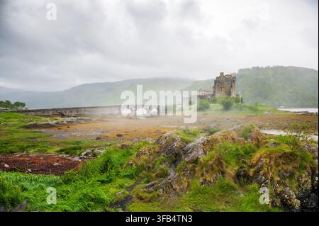 Ampia veduta del famoso castello di Eilean Donan e del suo ponte in una giornata nebbiosa, Scozia Foto Stock