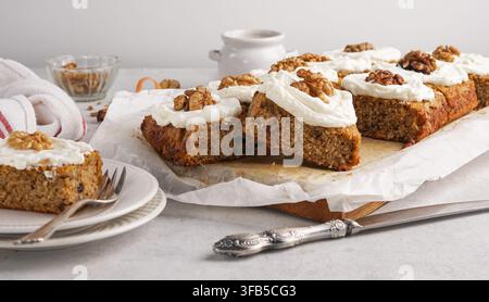 Barrette di torta alle carote fatte in casa con glassa al formaggio fresco e noci, deliziose fette di dessert dolci per feste o vacanze autunnali Foto Stock
