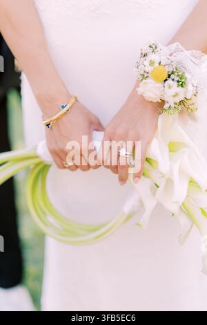 Sposa che tiene un elegante bouquet di calla bianca Foto Stock