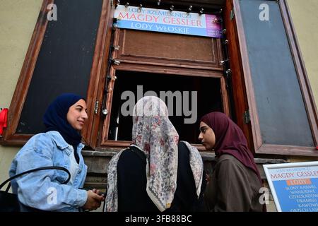 Tre giovani donne con hijab che chiacchierano mentre ordinano un gelato a una finestra di strada a Varsavia, Polonia. Foto Stock