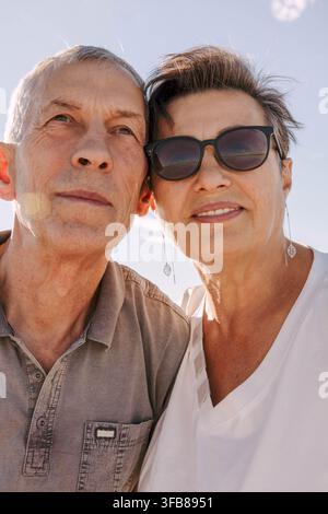 coppia di anziani. Uomo e donna anziani con occhiali da sole, espressioni calme e felici. sfondo cielo azzurro, stile di vita in pensione, relazione a lungo termine, amore Foto Stock