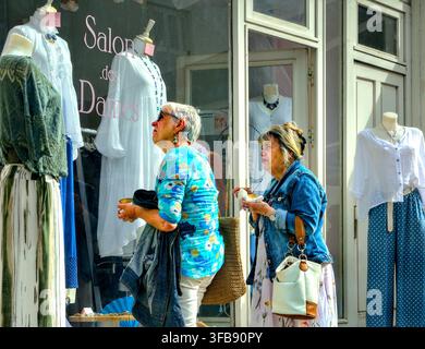 Due donne anziane che osservano abiti alla moda nella vetrina di un negozio di abbigliamento - Loches, Indre-et-Loire (37), Francia. Foto Stock