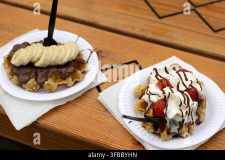 Due waffle di Liegi belgiani con guarnizioni di frutta e cioccolato Foto Stock