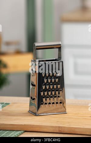 Utensile da cucina e preparazione dei pasti, grattugia a scatola in acciaio inossidabile su un tagliere di legno, attrezzatura per la preparazione alimentare Foto Stock