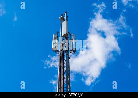 Antenna per telefoni mobili 5G contro un cielo blu con antenne a pannello utilizzate per la comunicazione cellulare Foto Stock