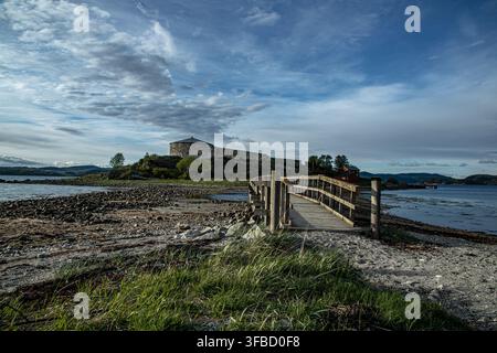 Storico ponte pedonale in legno che conduce al castello di Steinvikholmen su un'isola nel Trondheimsfjord, vicino a Stjørdal nel Trøndelag, Norvegia. Foto Stock
