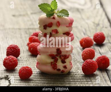 Una pila di macaron di lamponi e frutti di bosco cotti su un tavolo grigio Foto Stock