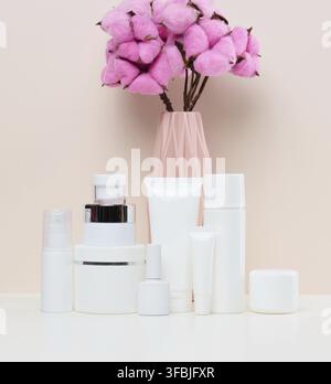 Vasetti e tubi in plastica bianca per cosmetici liquidi su fondo bianco. Branding, pubblicità Foto Stock