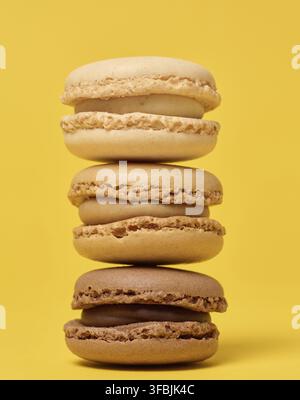 Pila di macaron di cioccolato su sfondo giallo Foto Stock