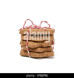 pila di biscotti di pan di zenzero al cioccolato a forma di stella legati con corda rossa e isolato su sfondo bianco Foto Stock
