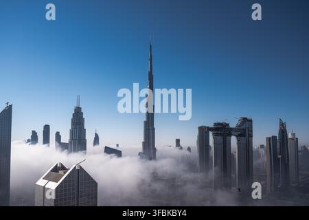 Grattacieli della skyline di Dubai che trafiggono la nebbia mattutina Foto Stock