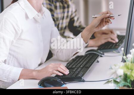 Programmatore pensieroso lavorando sul pc desktop codice di programmazione tecnologie o sito web design in ufficio azienda di sviluppo di software Foto Stock