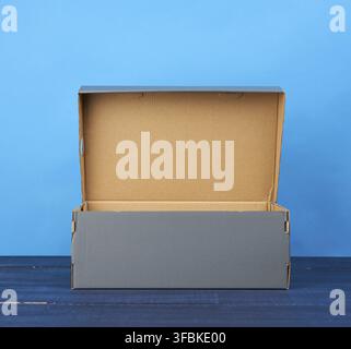 scatola vuota di cartone aperta per scarpe su sfondo blu, primo piano Foto Stock