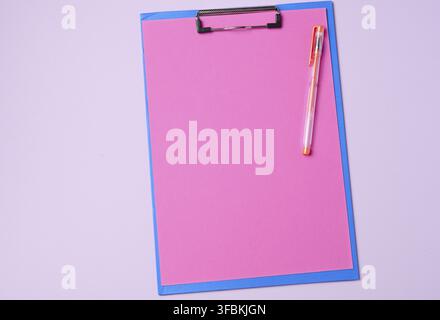 Supporto blu con fogli rosa puliti su sfondo viola, vista dall'alto Foto Stock