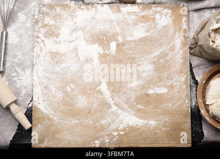 farina di grano bianco, tondino di legno e tagliere vecchio su un tavolo, vista dall'alto Foto Stock
